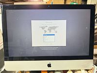 iMac powered on at welcome screen showing display and front design