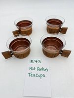 Four glass and wood tea cups top view