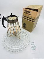 Carafe on warmer stand next to pressed-glass tray and original box