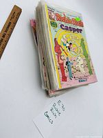 Stack of bagged Richie Rich comics next to ruler