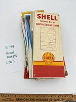 Stack of approximately 30 folded road maps, top map Shell Sectional Map of South Central States