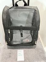 Front view of Snoozer rolling pet carrier showing mesh panel, zippers, brand patch