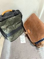 Tumi Tech green nylon laptop bag and Pad & Quill brown leather messenger side by side