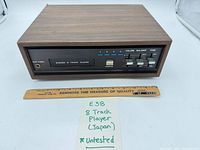 Front view of stereo 8-track player showing controls and woodgrain cabinet