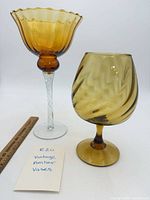 Both amber glass vases side by side with ruler for scale