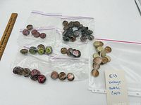 Overview of all resealable bags containing vintage soda bottle caps with ruler for scale