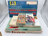 Stack of six game boxes with Television’s Number Please board displayed behind