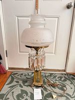 Full view of lamp standing on floor showing base, prisms, shade, cord