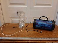 Speaker, lamp and USB cable displayed on table with ruler for scale