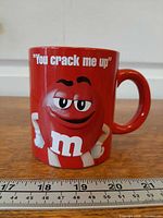 Front view of red M&M's mug showing slogan and character