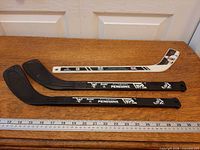 All three mini hockey sticks laid out with ruler for scale
