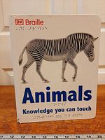 Front cover showing title, zebra image, braille lettering