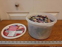 Open ice cream tub beside lid showing visible crayons