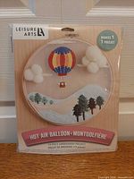 Front of sealed Leisure Arts hot air balloon embroidery kit package