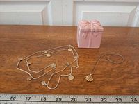 Overview of both necklaces and trinket box with ruler for scale