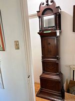 Full view of tall-case clock showing bonnet, glass door, mid and lower sections