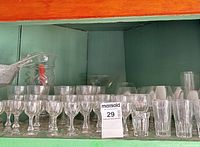 Shelf showing majority of cordial, wine and tumbler glasses, pitcher and decanter