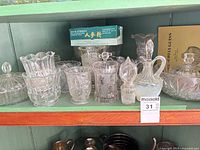 Shelf view showing decanter, covered dishes, small bowls and original lot tag