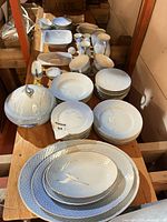 Full lot layout showing plates, bowls, serving pieces and covered dish