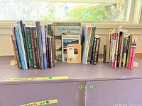 Front view of full lot showing two rows of approximately 35 books between metal bookends