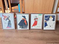Group shot of four framed poster prints standing side by side
