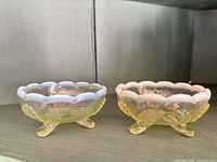 Two opalescent ruffled tripod bowls, side view