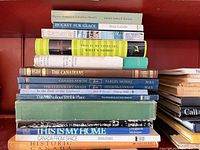Stack of Canadian themed books showing titles such as Hockey Sur Glace, This Is My Country, What's Yours?, The Canadians and others