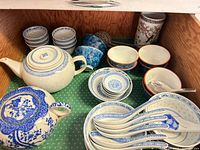 drawer view showing assorted blue-and-white porcelain pieces, teapots, spoons, bowls, cups and tumbler