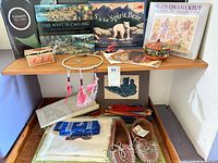 Overall lot showing books, boxes, dreamcatcher, moccasins, textiles