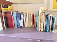Shelf showing full lot of approximately 28 books across travel, reference and medical genres