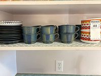 Full set on shelf showing cups, plates, bowls together