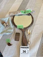 Grouped lot showing mirror, spoon, necklace, money clip, wine spout, polishing cloths
