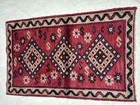 Full view of Shiraz wool rug showing geometric design and border