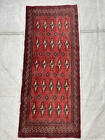 Full view of the rectangular red Torkaman carpet on neutral background