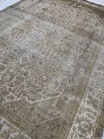 Angled close view highlighting faded beige/taupe design and low pile