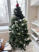 Full view of assembled tree showing height, ornaments, and stand