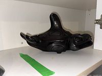 Left side view of carved black stone orca showing overall shape and lid seam