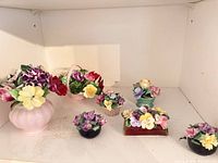 Group shot of eight miniature floral posies on shelf
