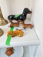 Group view of five dachshund figurines on shelf