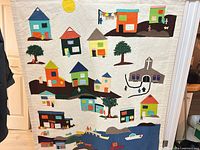 Full view of quilted wall hanging depicting entire village scene