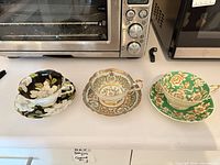 Three Paragon cup and saucer sets displayed side by side