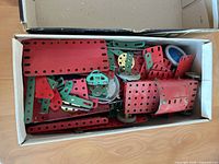 box of assorted red and green Meccano plates and strips