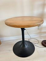 Full view of round wood-top tulip pedestal table
