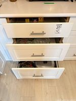 Three drawers showing roasting pan, grill pan, glassware