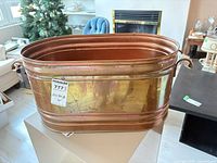Full side view of oval copper planter showing patina and ribbed design