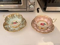 Full view of both teacup and saucer pairs showing colors and design