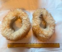 Both fur cuffs side by side with ruler for scale