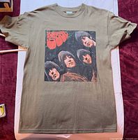Full view of army green Beatles Rubber Soul T-shirt laid flat