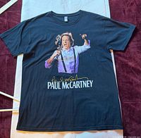 Front view of black Paul McCartney 2010 tour T-shirt laid flat