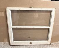 Front view of vintage white wood window showing two panes and latch